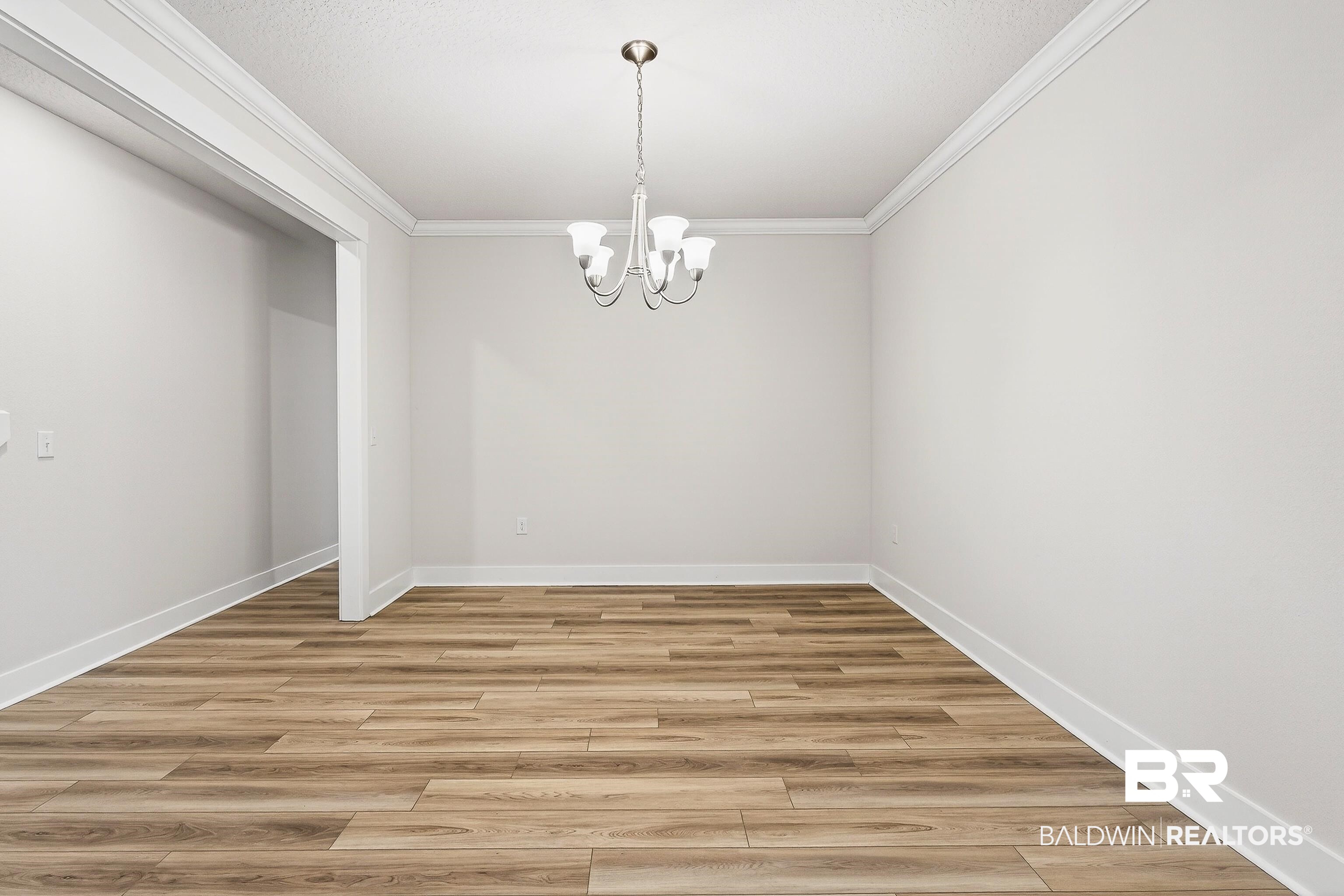 1728 Partridge Street Foley, AL 36535 - Photo 7 of 37 Unfurnished room featuring a chandelier, crown molding, and light wood finished floors