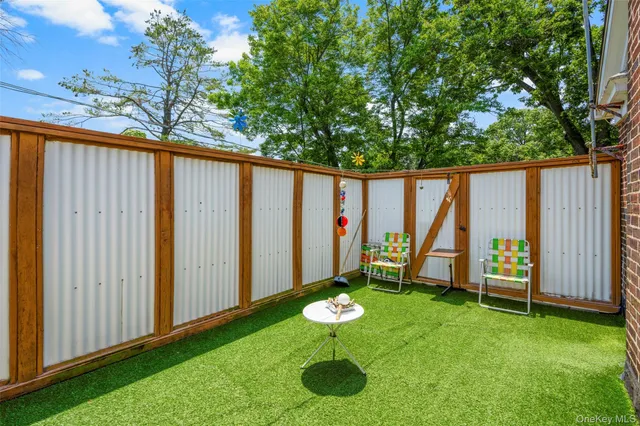 a view of a chair and table in backyard of the house