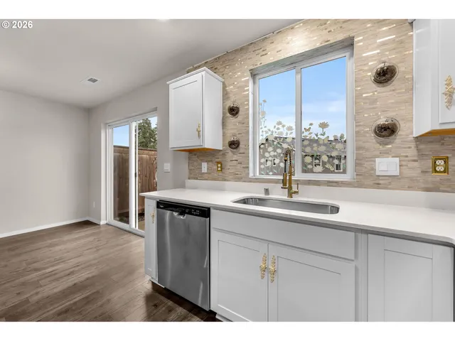 a kitchen with stainless steel appliances a sink a stove a microwave a sink and cabinets