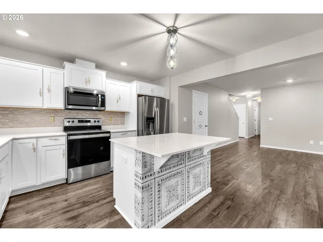 a view of kitchen with cabinets microwave and stove