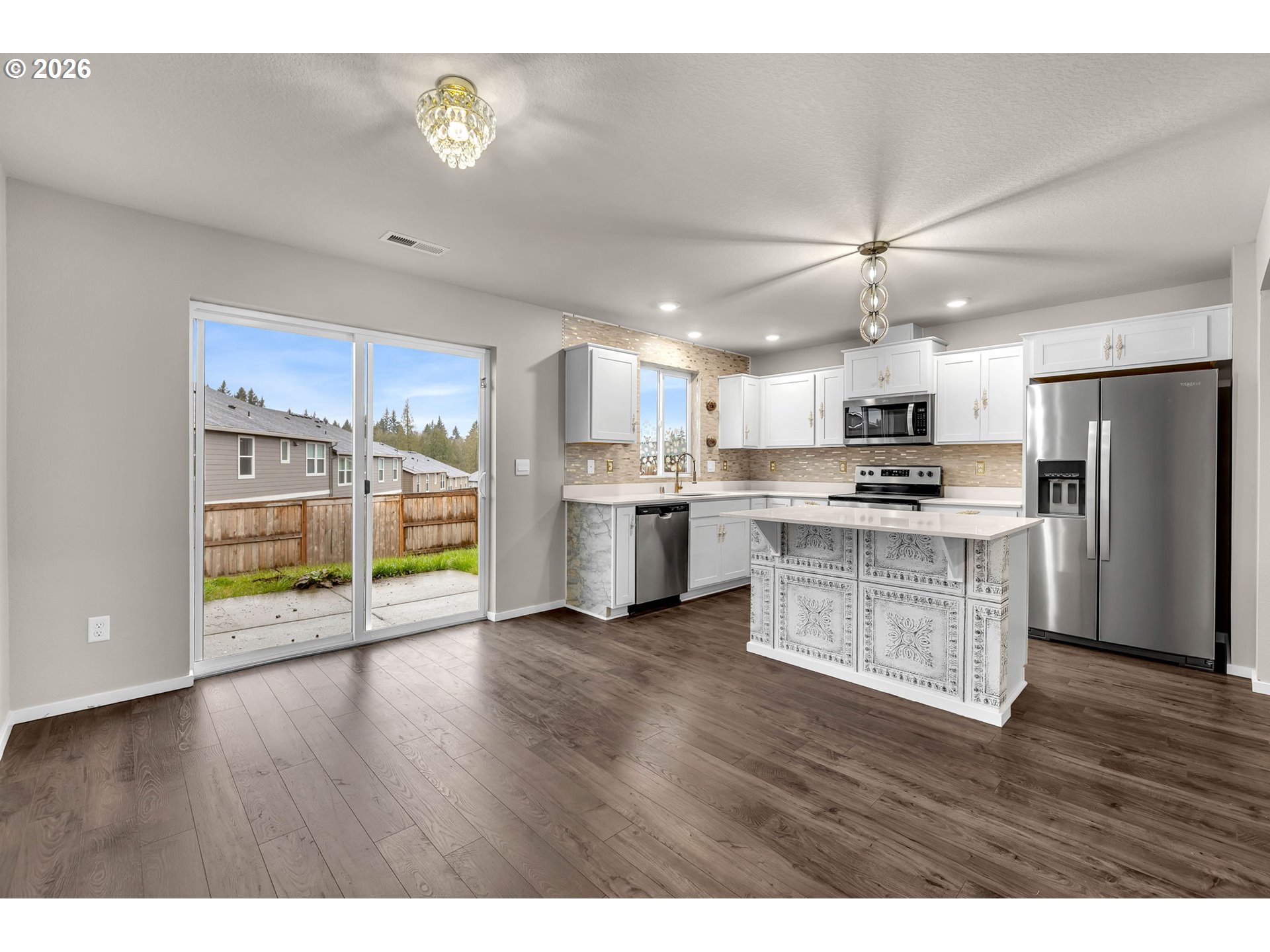 2933 North 3rd Way Ridgefield, WA 98642 - Photo 18 of 37 a kitchen with stainless steel appliances a refrigerator a stove top oven and a wooden floor