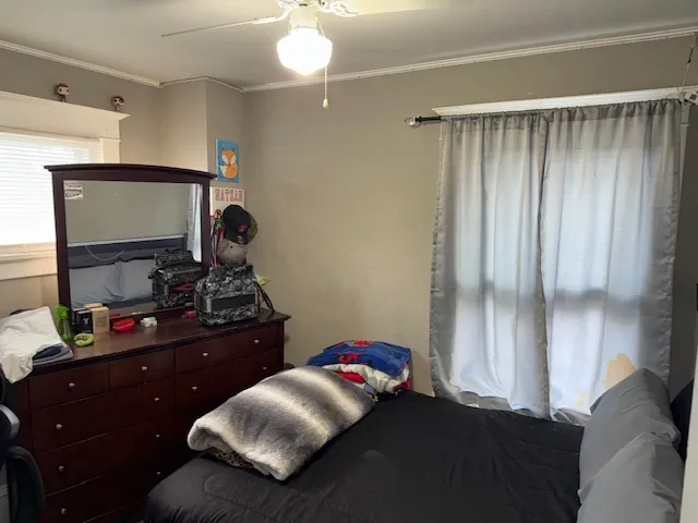 a bedroom with a bed and a mirror on the dresser