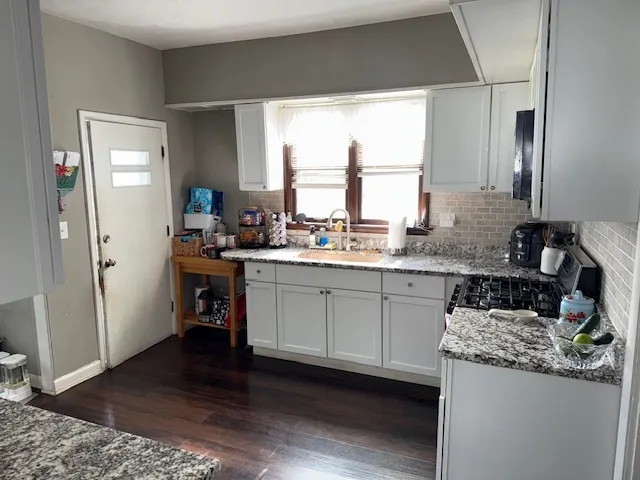 a kitchen with stainless steel appliances granite countertop a stove a sink and a refrigerator