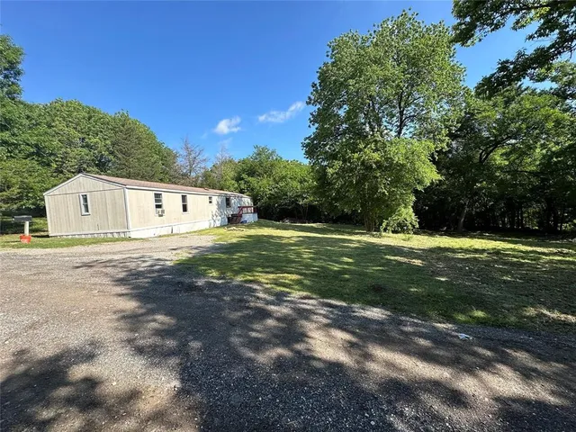 a view of a big yard with large trees