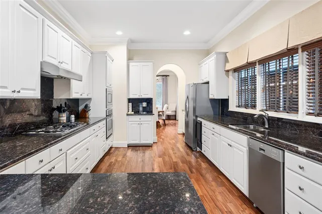 a large kitchen with stainless steel appliances lots of counter space and windows