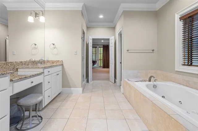 a spacious bathroom with a tub sink and mirror