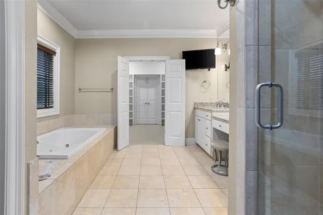 a bathroom with a tub a sink and a large mirror