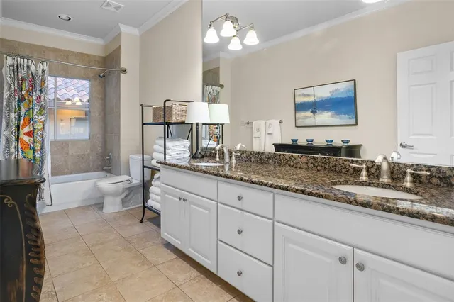 a spacious bathroom with a granite countertop sink a toilet a mirror and a shower