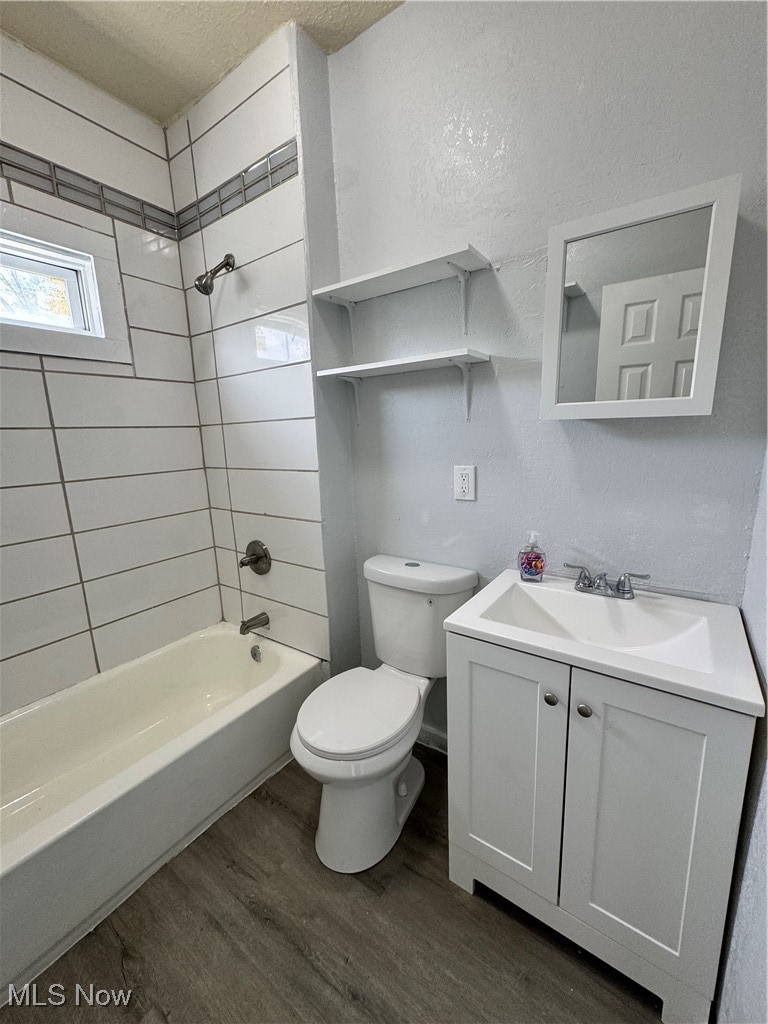 3624 East 118th Street Cleveland, OH 44105 - Photo 16 of 49 Bathroom with a textured ceiling, wood finished floors, vanity, and shower / bathtub combination
