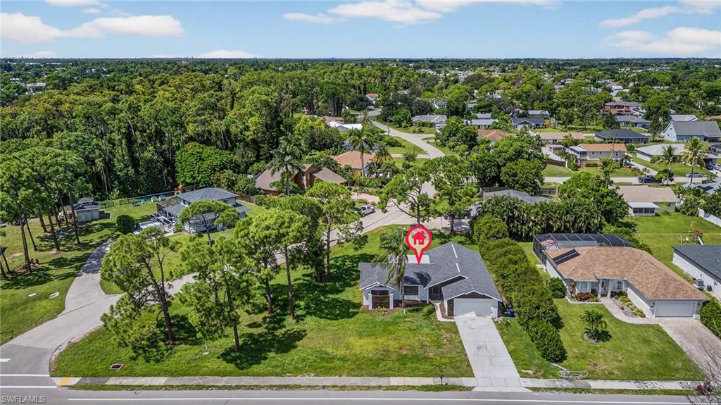 an aerial view of residential houses with outdoor space and trees