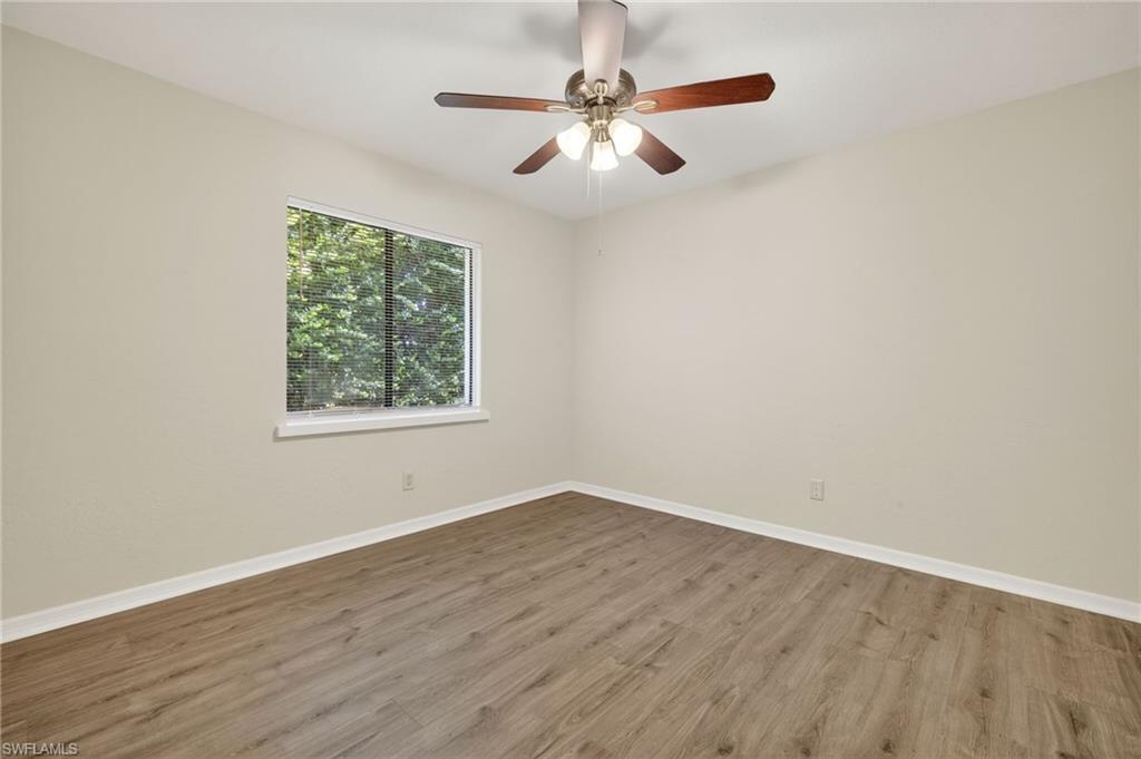 18294 Lee Road Fort Myers, FL 33967 - Photo 23 of 37 an empty room with wooden floor ceiling fan and windows