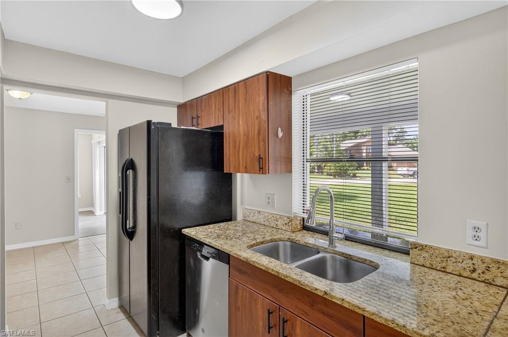 18294 Lee Road Fort Myers, FL 33967 - Photo 5 of 37 a kitchen with granite countertop a sink and refrigerator
