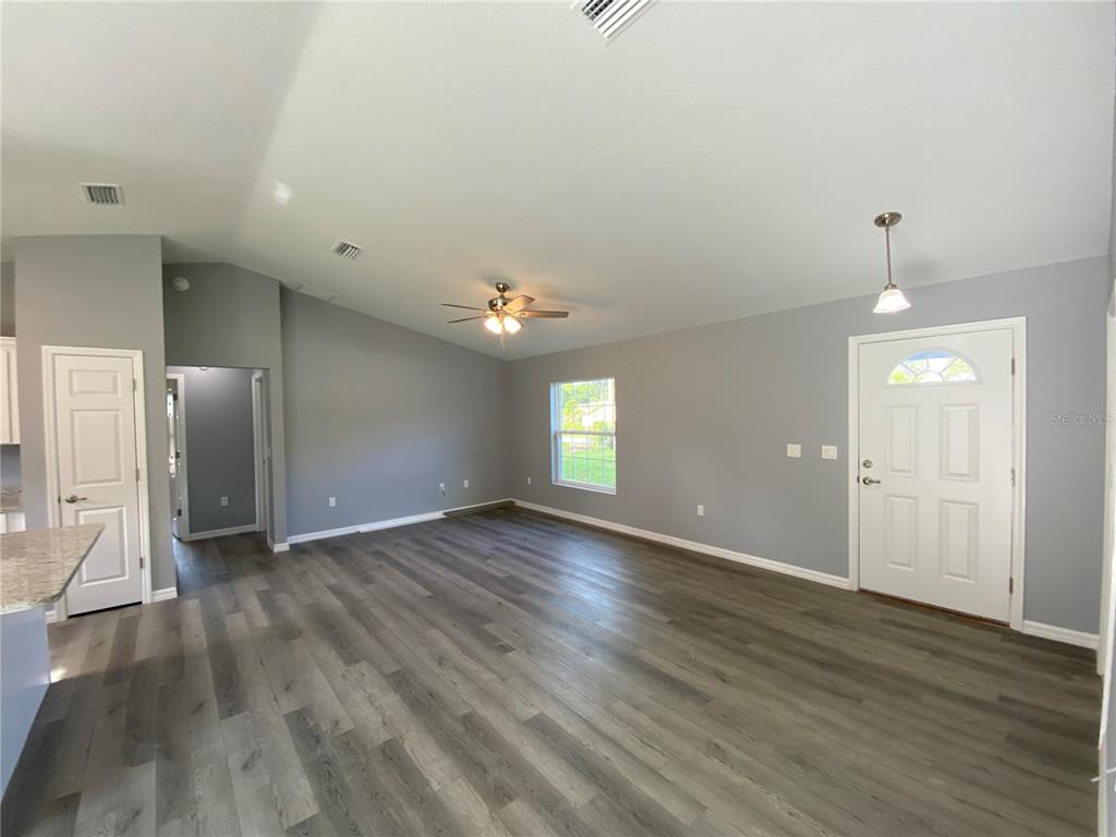 2827 Southwest 140th Loop Ocala, FL 34473 - Photo 11 of 29 an empty room with wooden floor and mirror