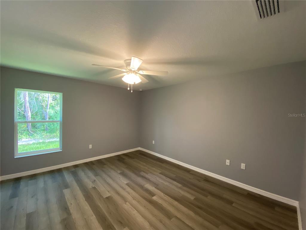 2827 Southwest 140th Loop Ocala, FL 34473 - Photo 13 of 29 a view of an empty room with wooden floor and a window