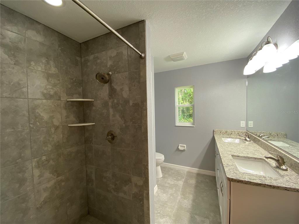 2827 Southwest 140th Loop Ocala, FL 34473 - Photo 19 of 29 a bathroom with a granite countertop sink a shower and a mirror