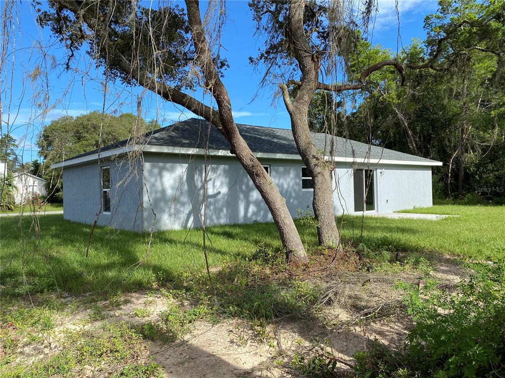 2827 Southwest 140th Loop Ocala, FL 34473 - Photo 28 of 29 a backyard of a house with plants and wooden fence