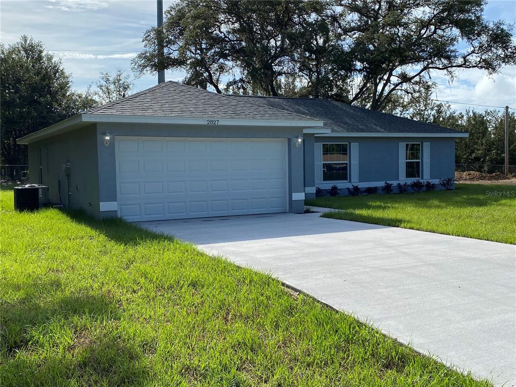 2827 Southwest 140th Loop Ocala, FL 34473 - Photo 3 of 29 a view of a yard in front of a house with large tree