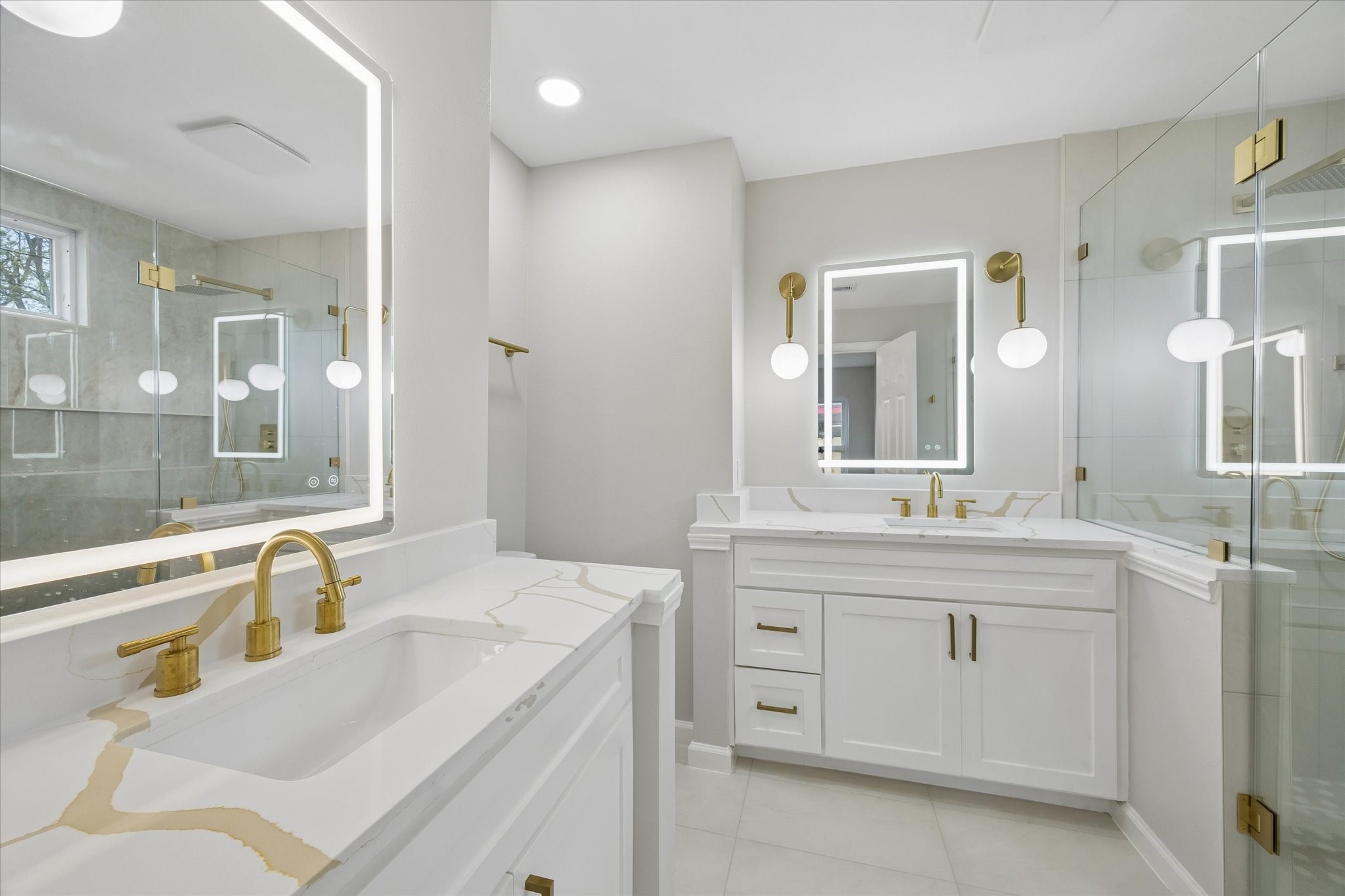 a bathroom with a sink double vanity granite tub shower and a mirror