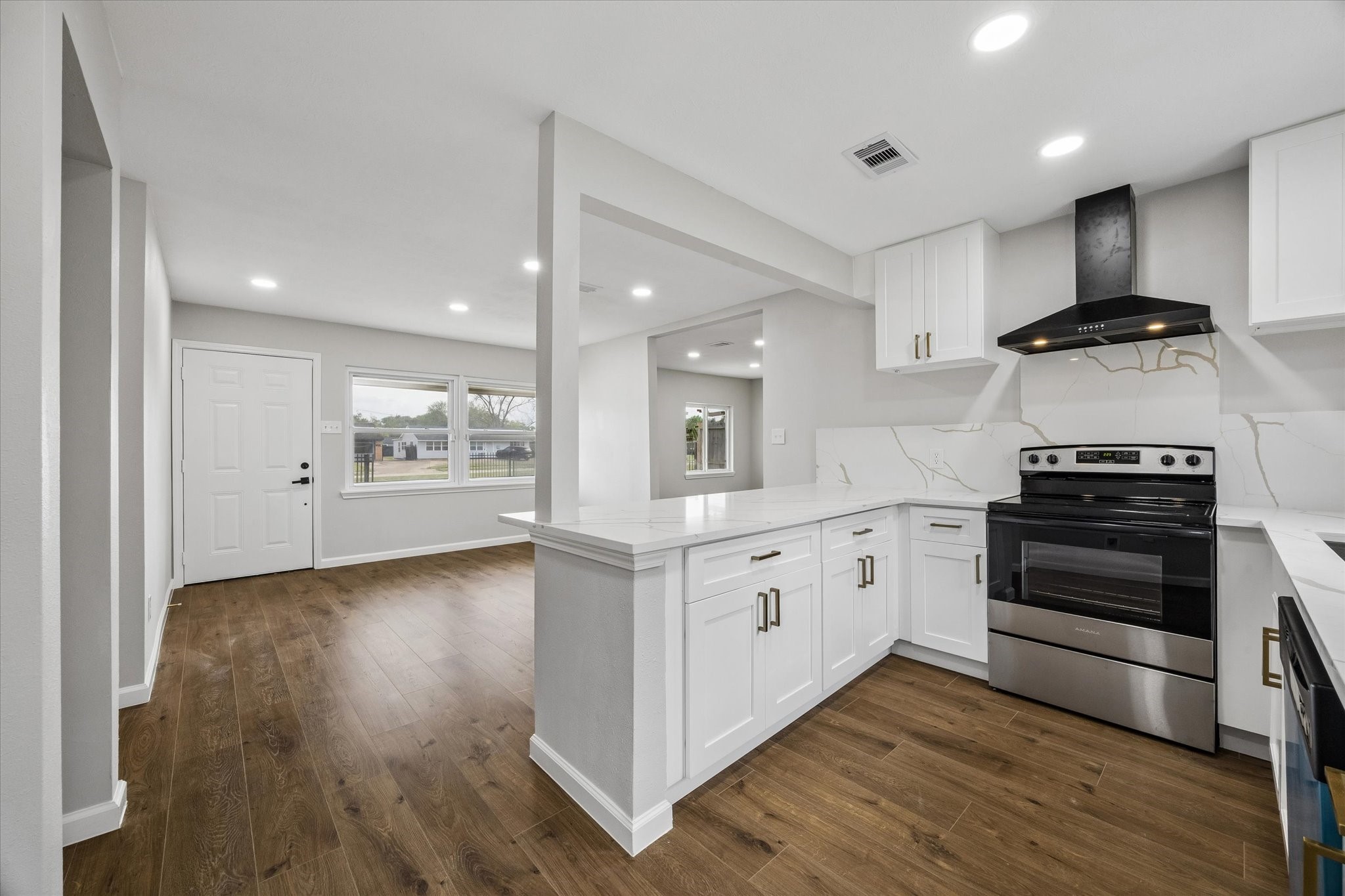 4203 Mowery Road Houston, TX 77047 - Photo 4 of 16 a kitchen with stainless steel appliances white cabinets and wooden floors