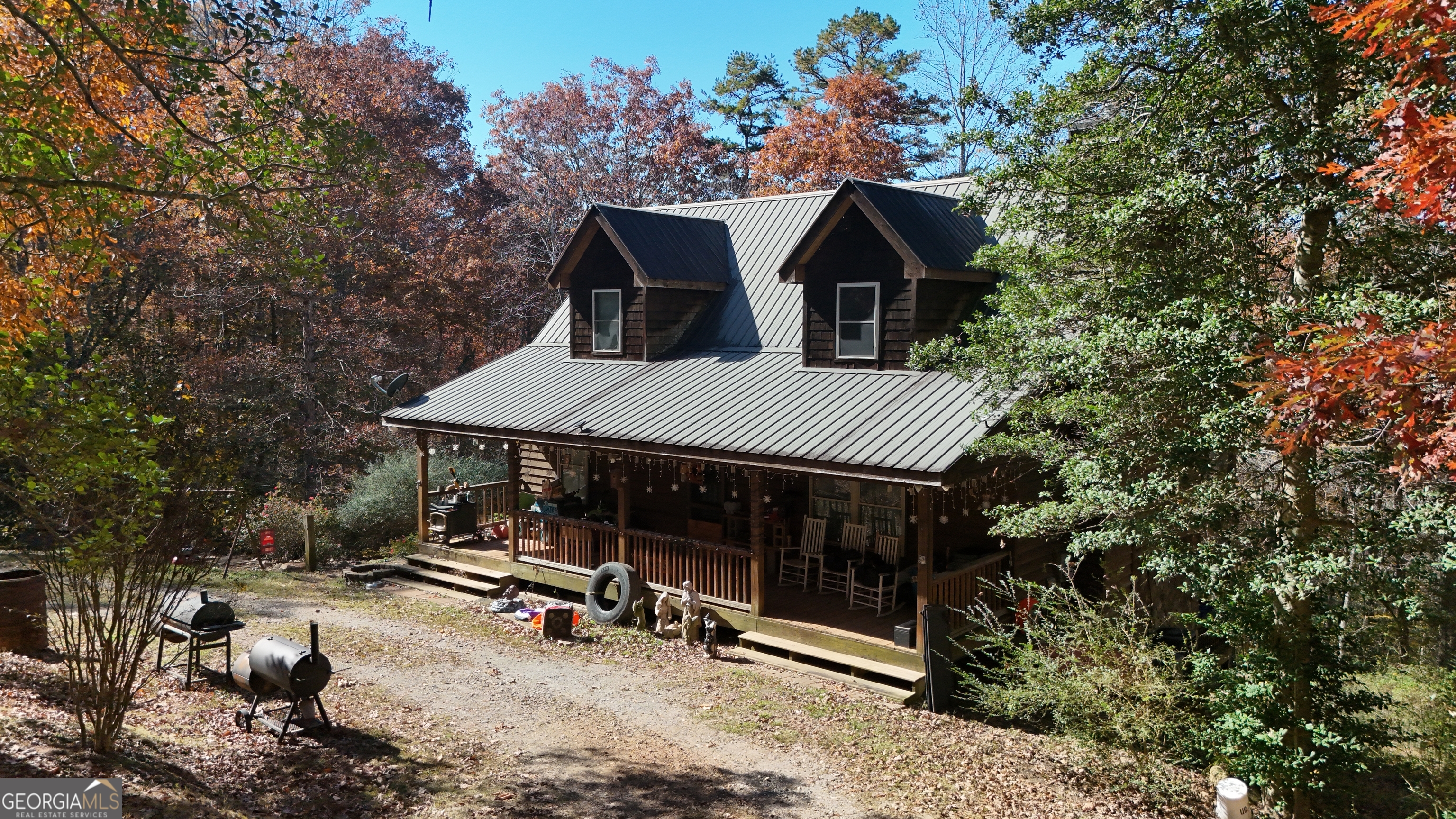 a view of house with yard furniture and trees