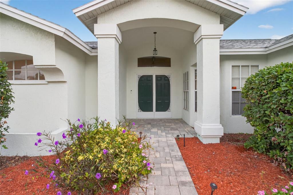 8841 Kipling Avenue Hudson, FL 34667 - Photo 7 of 41 a front view of a house with a flower garden