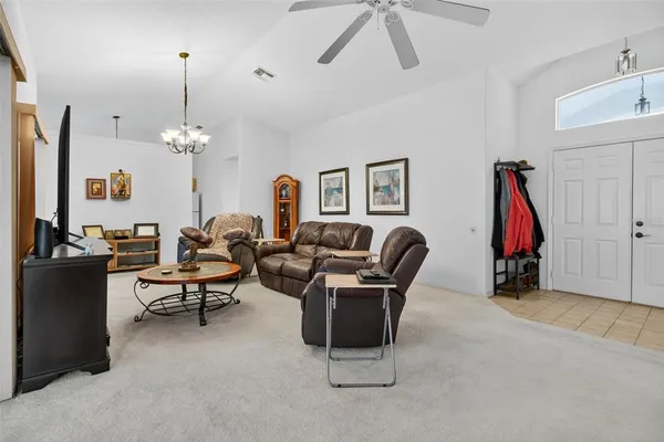a living room with furniture a flat screen tv and a window