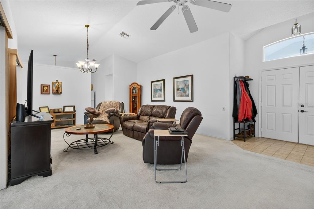 8841 Kipling Avenue Hudson, FL 34667 - Photo 10 of 41 a living room with furniture a fireplace and a chandelier