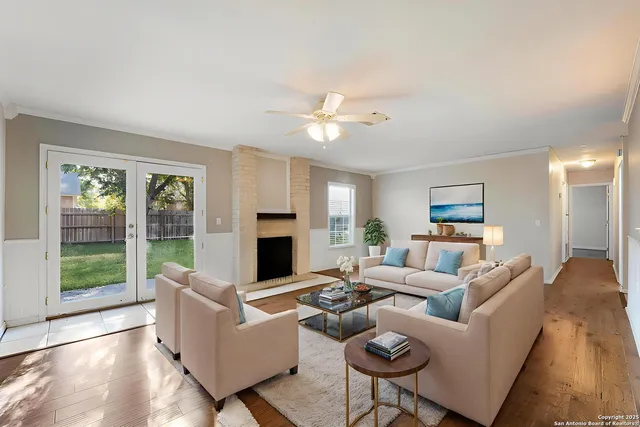 a living room with furniture fireplace and a large window
