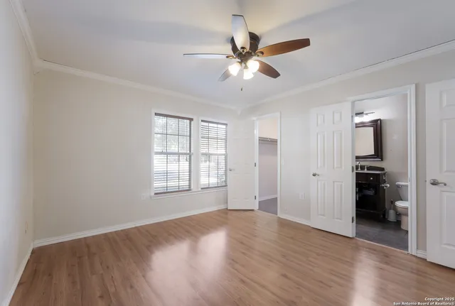 a view of an empty room with a window and wooden floor