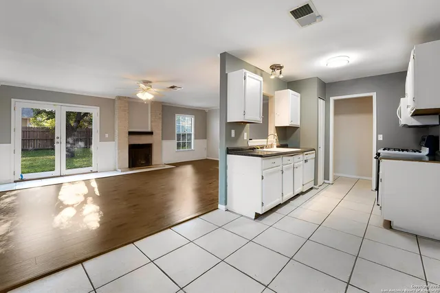 a kitchen with granite countertop a stove a sink and a refrigerator