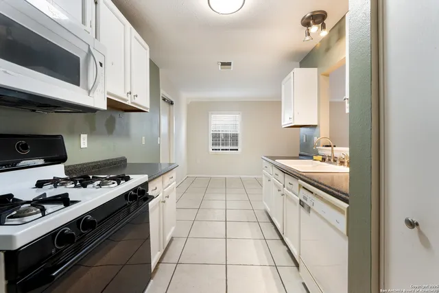 a kitchen with stainless steel appliances a stove a sink and cabinets