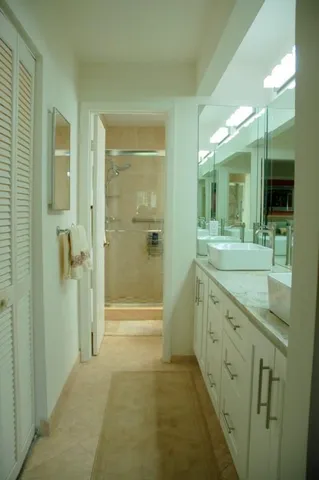 a spacious bathroom with a granite countertop sink mirror and shower