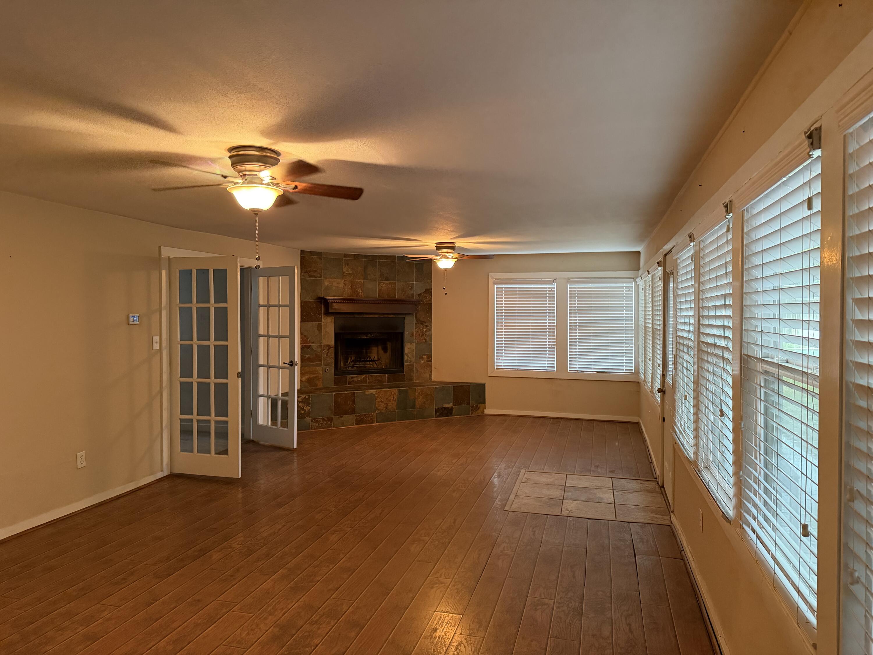 3110 22nd Street Lubbock, TX 79410 - Photo 8 of 22 a view of empty room with a fireplace and wooden floor