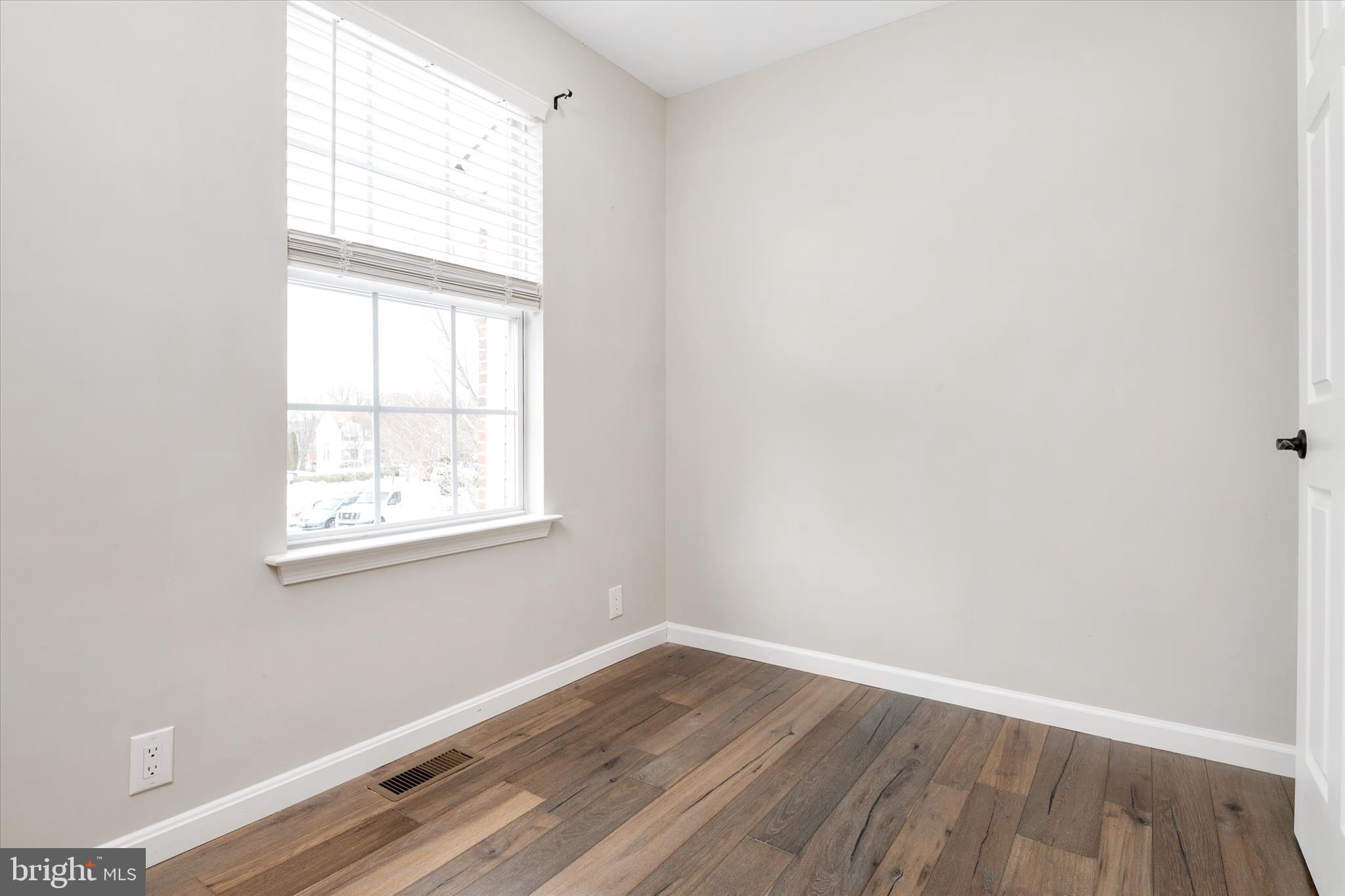 1711 Glebe Creek Way Odenton, MD 21113 - Photo 22 of 33 an empty room with wooden floor and windows