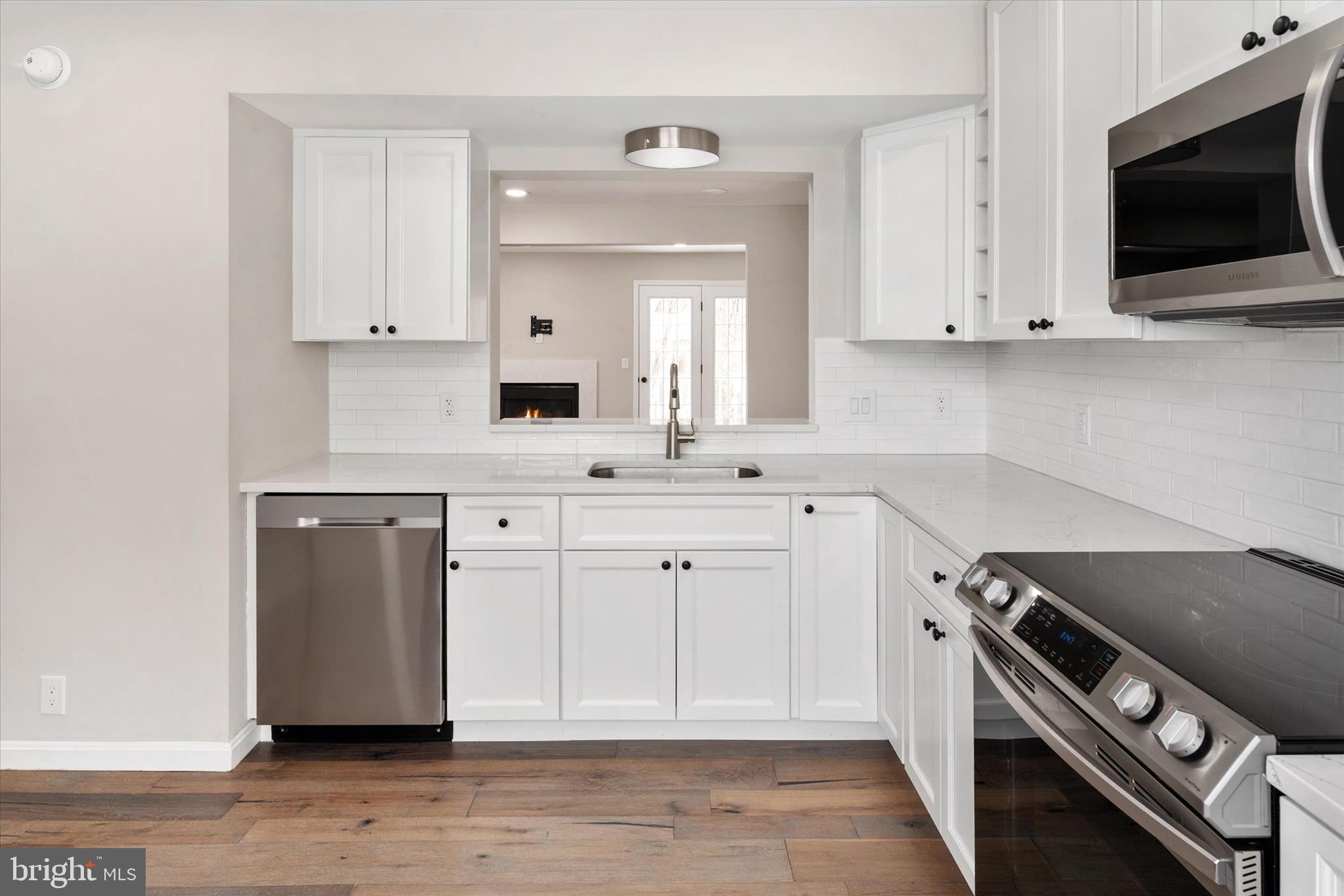 1711 Glebe Creek Way Odenton, MD 21113 - Photo 6 of 33 a kitchen with white cabinets and a stove top oven