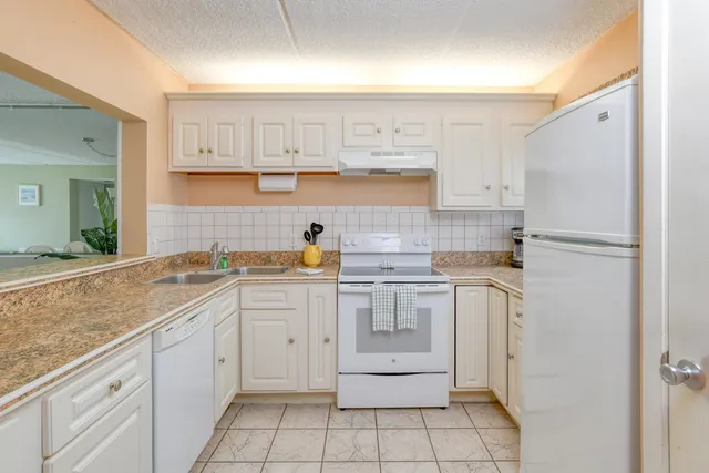 a kitchen with white cabinets and white appliances