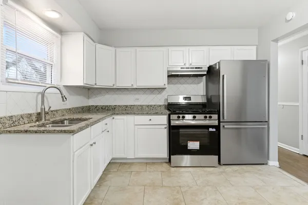 a kitchen with stainless steel appliances granite countertop a refrigerator sink and stove