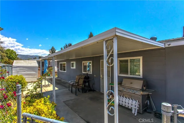 a patio with table and chairs and potted plants