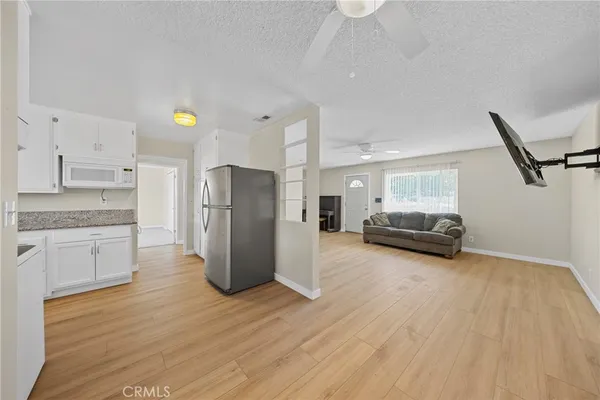 a kitchen with wooden floors and white appliances