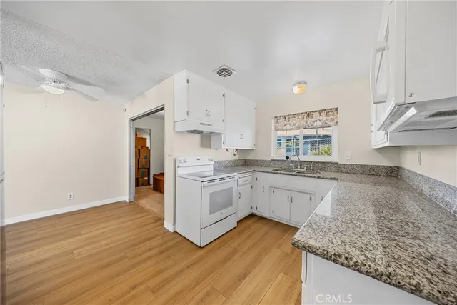 a kitchen with wooden floors and white appliances
