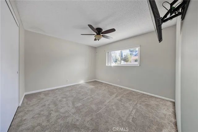 an empty room with windows and ceiling fan view