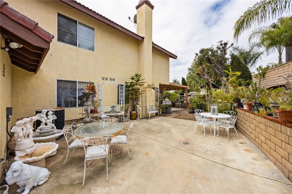 6990 Stanislaus Place Rancho Cucamonga, CA 91701 - Photo 17 of 25 a view of a patio with dining table and chairs with plants
