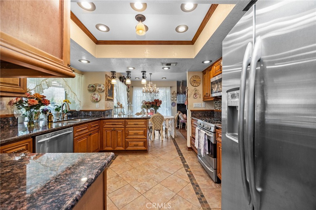 6990 Stanislaus Place Rancho Cucamonga, CA 91701 - Photo 7 of 25 a kitchen with stainless steel appliances granite countertop a refrigerator a sink and a stove