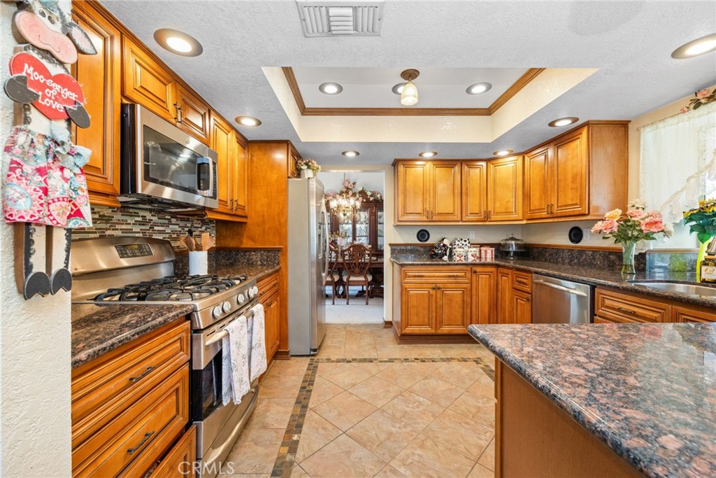 6990 Stanislaus Place Rancho Cucamonga, CA 91701 - Photo 8 of 25 a kitchen with stainless steel appliances granite countertop sink stove and granite counter top