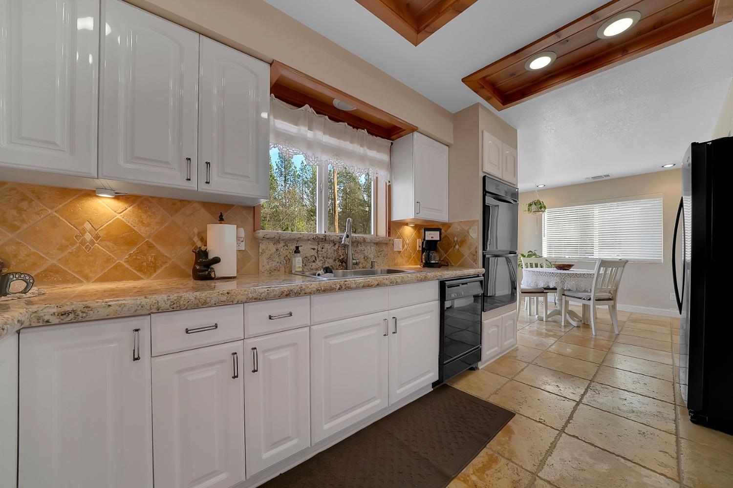 301 Bald Mountain Road West Point, CA 95255 - Photo 11 of 55 a kitchen with granite countertop white cabinets stainless steel appliances a sink and a counter top space