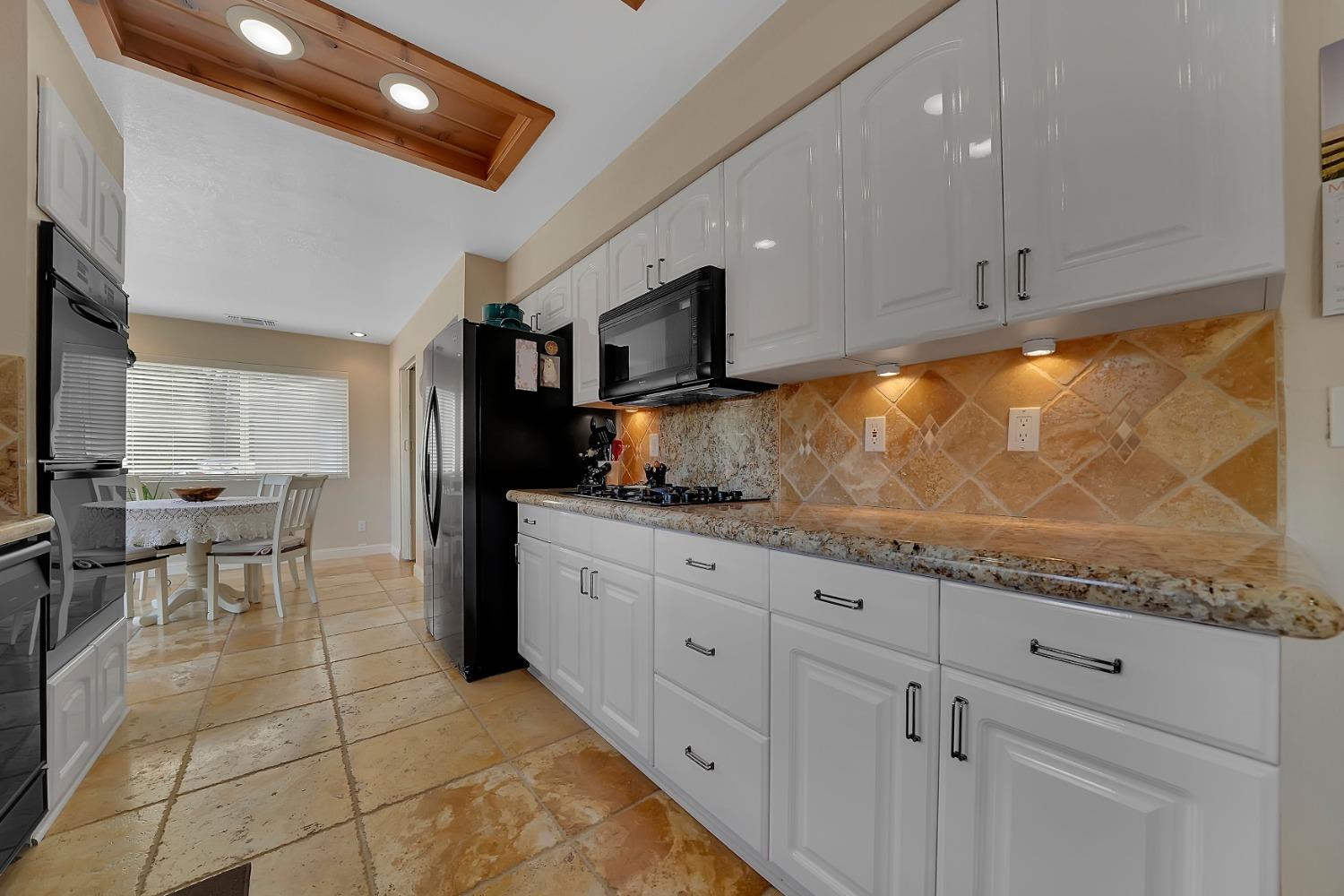 301 Bald Mountain Road West Point, CA 95255 - Photo 12 of 55 a kitchen with granite countertop a stove a sink and a refrigerator