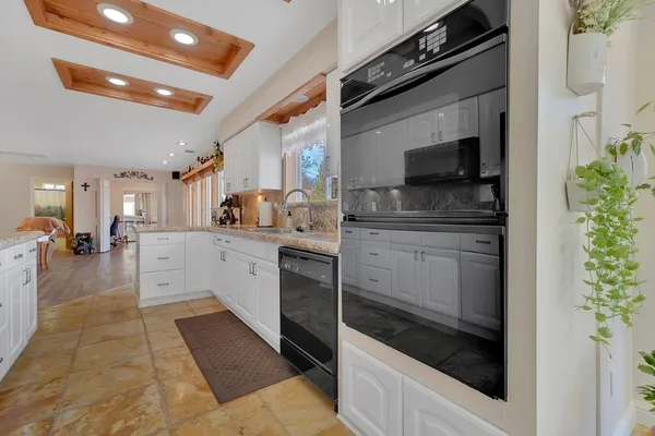 a kitchen with granite countertop a sink stainless steel appliances and cabinets