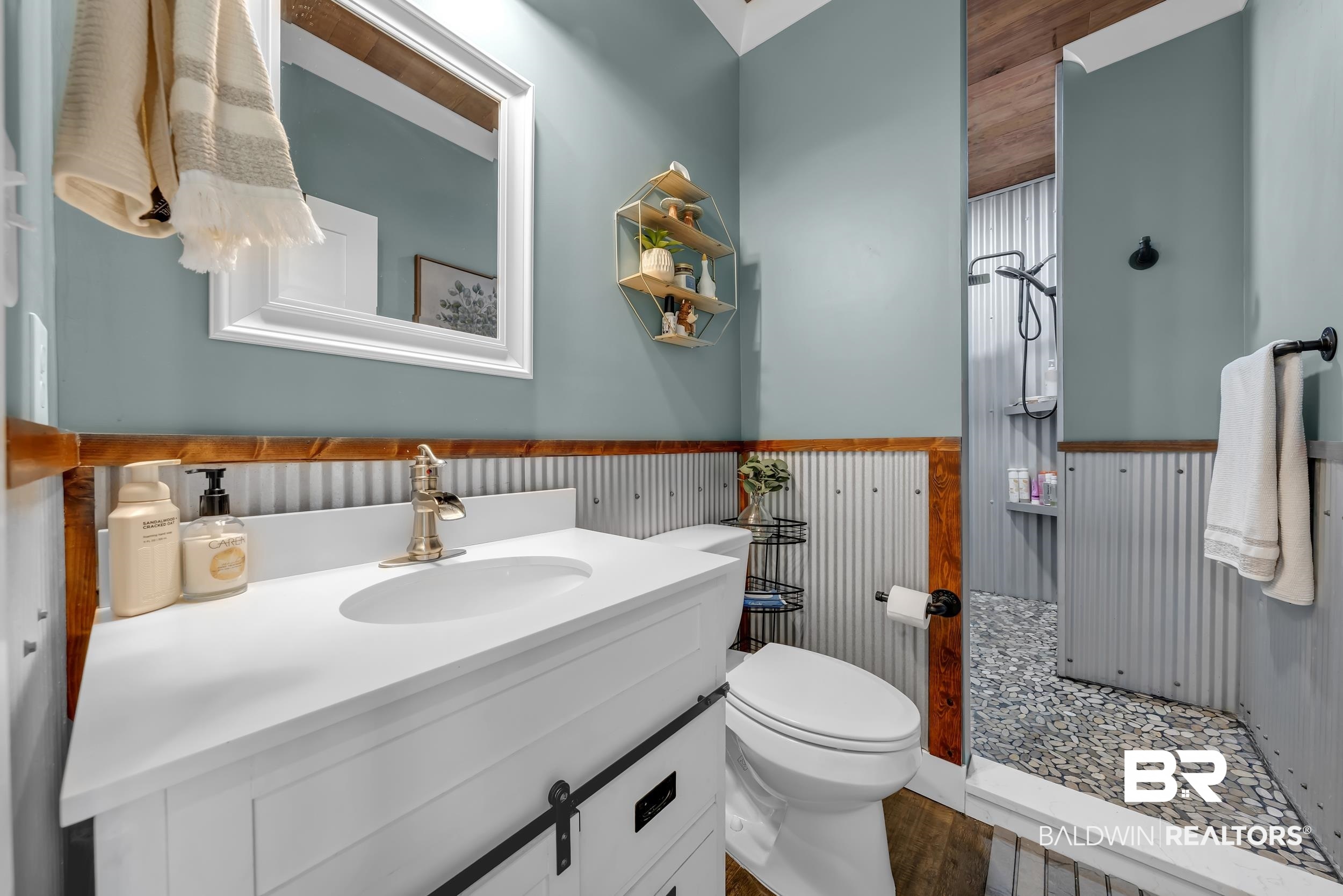 6576 Ranch Loop Road East Grand Bay, AL 36541 - Photo 21 of 39 Bathroom featuring a white vanity with integrated sink, brass-finish faucet, and a framed mirror