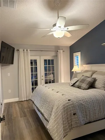 a bedroom with a large bed and a flat tv screen
