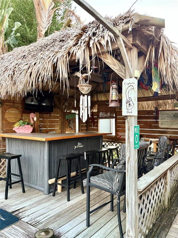 802 Woodhill Court Palm Harbor, FL 34683 - Photo 19 of 20 a view of a patio with table and chairs with wooden floor and fence
